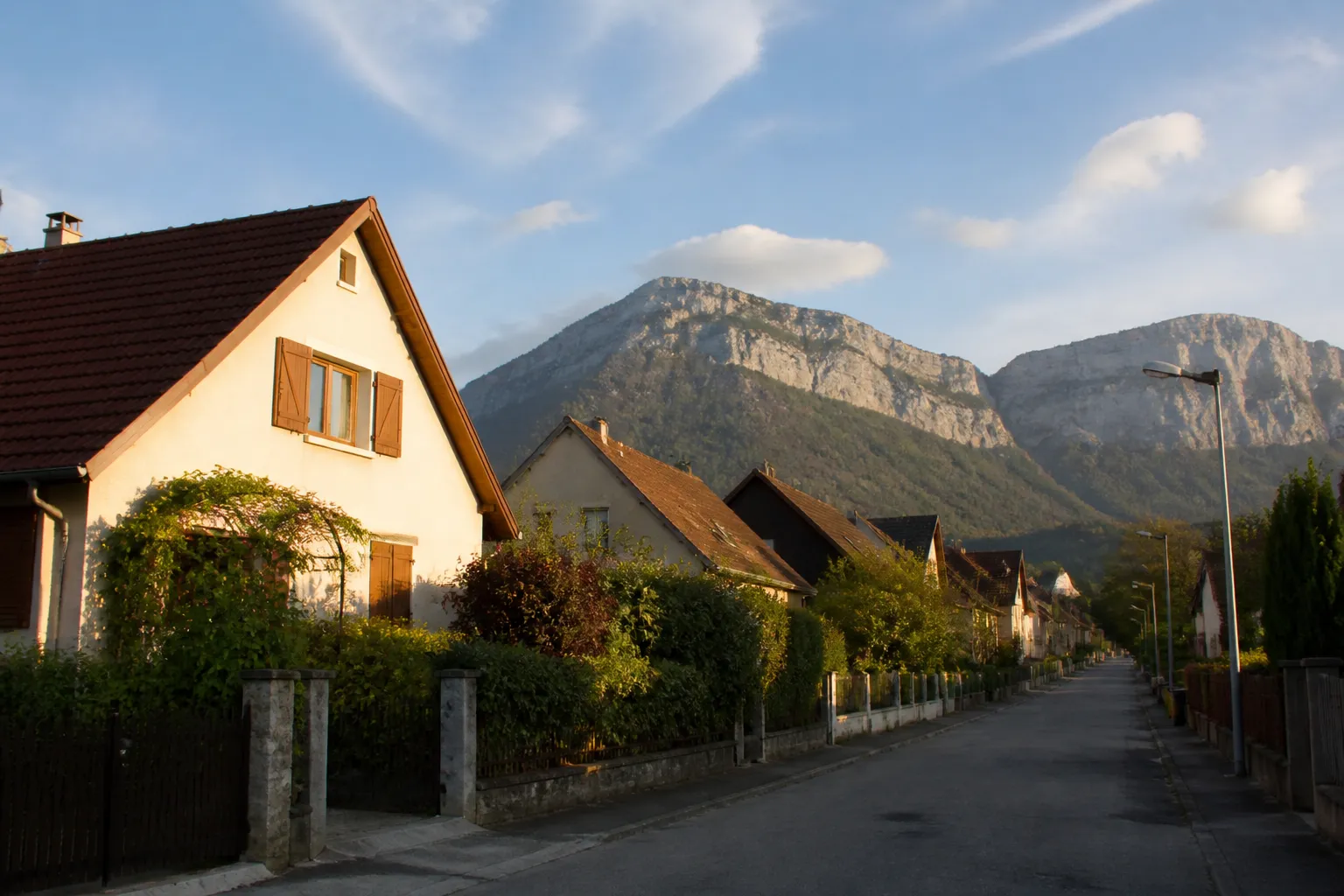 Rangée de maisons individuelles à toiture en pente au pied d’un massif montagneux